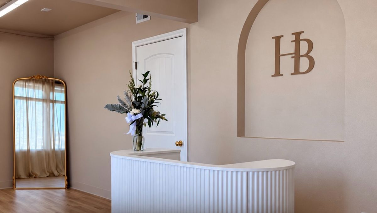 Reception desk with the HB logo wall